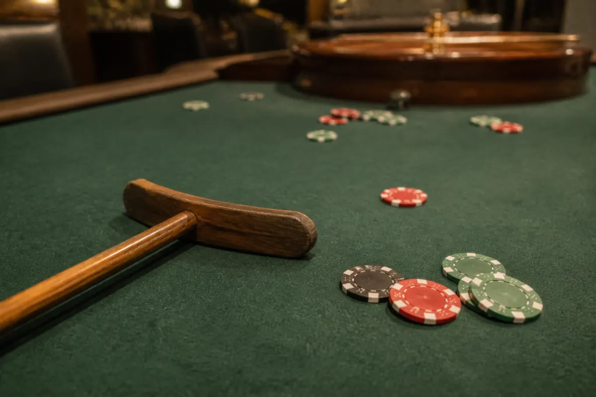 Foto eines gebrauchten Casino-Tischs mit Holzrechen und Chips
